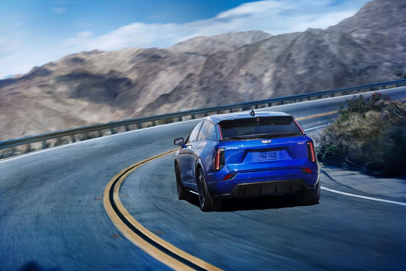 Rear View of a Blue 2026 OPTIQ-V Driving on a Curve of a Mountain Row | Jessup Cadillac in CATHEDRAL CITY CA
