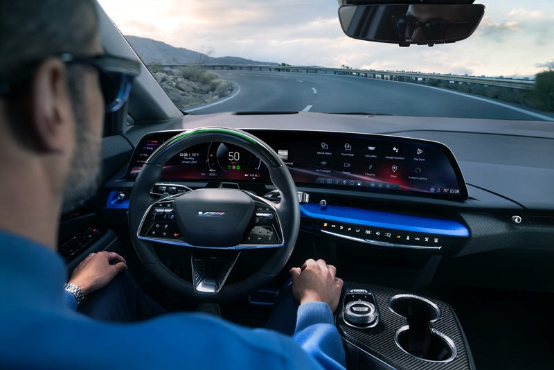 Front View of the 2026 OPTIQ-V Driving Through the Dusk Utilizing its Headlights | Jessup Cadillac in CATHEDRAL CITY CA