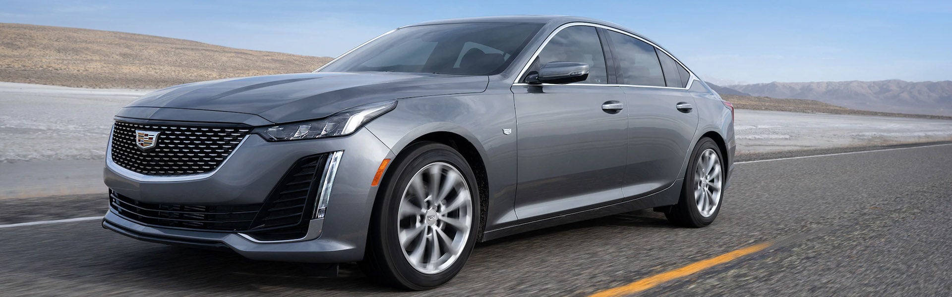 Gray Cadillac CT5 driving down the road at high speed