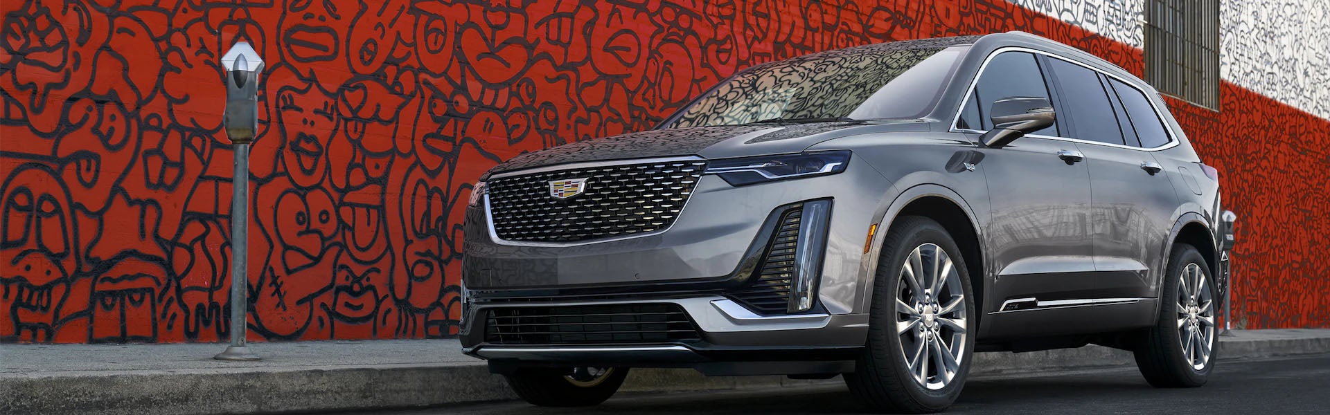 Gray Cadillac XT6 parked on the street next to a coin meter
