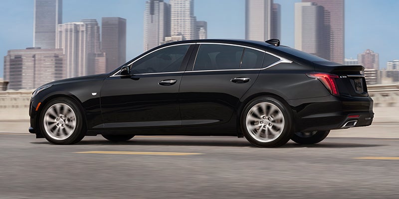 Cadillac CT5 driving down the road at high speed towards the city on a sunny day