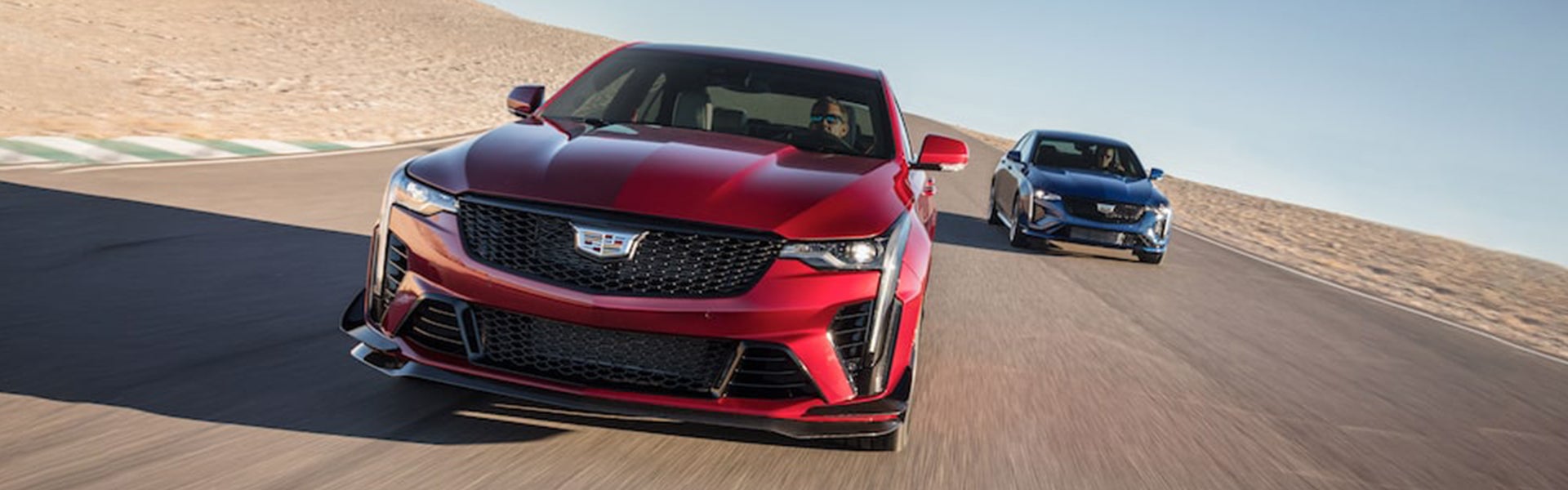 two Cadillac CT4-V's racing against each other on a race track