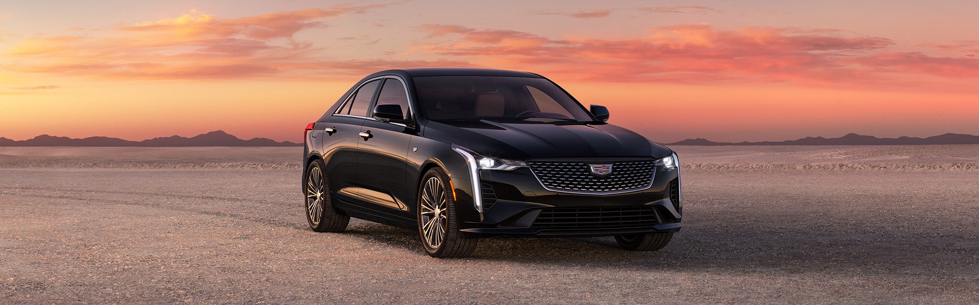 Black Cadillac CT4 parked in the desert while it is becoming dusk outside