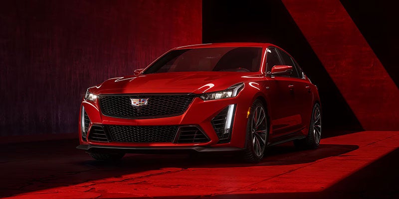Red Cadillac CT5-V parked in a garage with red lights shinning on the vehicle