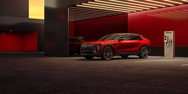 Red Cadillac LYRIQ parked at a fuel station inside of a garage